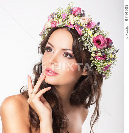 Young Beauty. Woman's Face with Bouquet of Natural Flowers 9744905