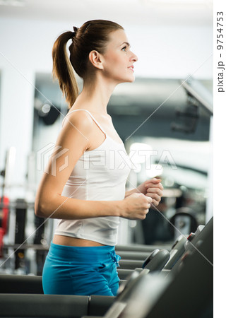 attractive young woman runs on a treadmill attractive young woman runs on a treadmill 9754753