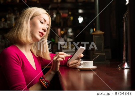 woman with a cup of coffee and cell phone 9754848