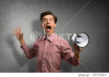 Portrait of a young man shouting using megaphone Portrait of a young man shouting using megaphone 9755693