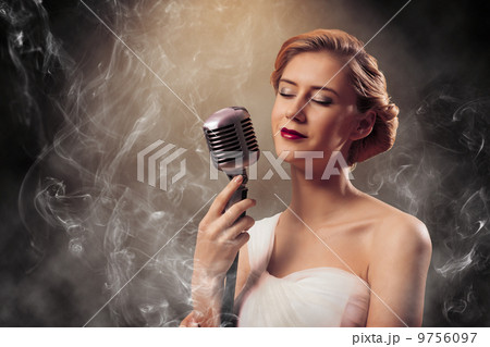 beautiful blonde woman singer with a microphone 9756097
