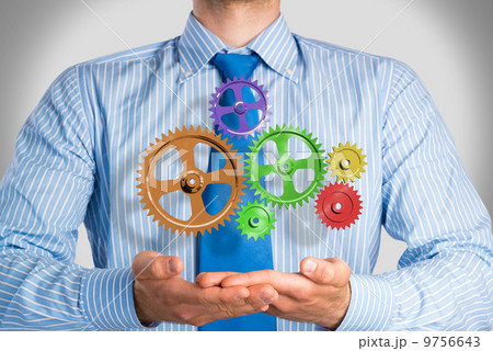 business man holds up a mechanism of gears 9756643