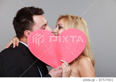 happy bride and groom kissing behind red heart happy bride and groom kissing behind red heart 9757401