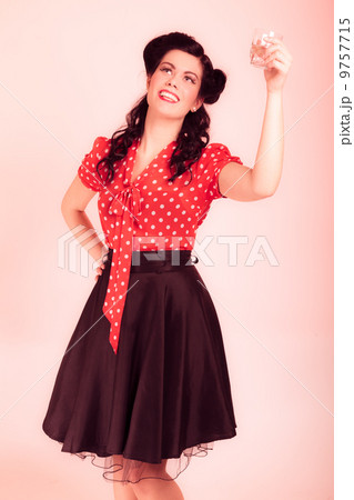 Woman drinking water. Girl with pinup makeup and hairstyle. Retro. 9757715