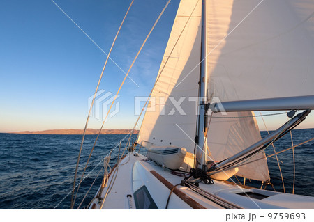 Sailboat during the regatta at sunset ocean 9759693
