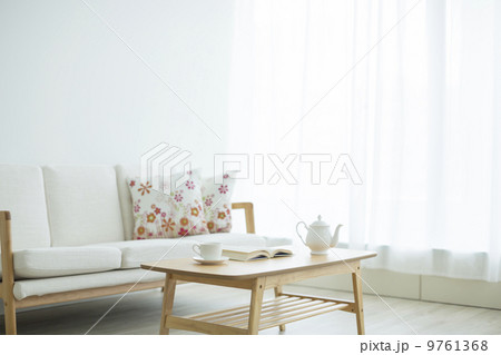 リビングルームに置かれた本とティーセット 9761368