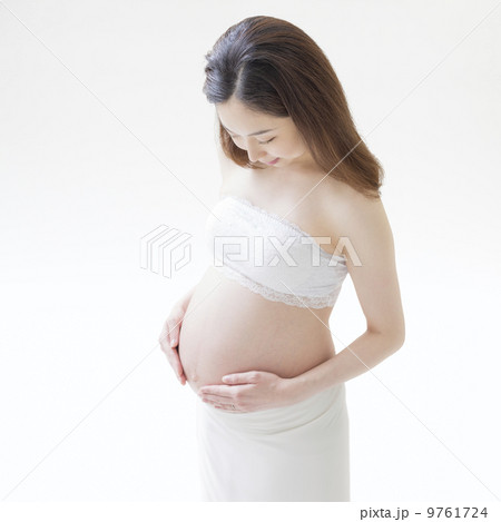 お腹に手をあてて立つ妊婦 9761724