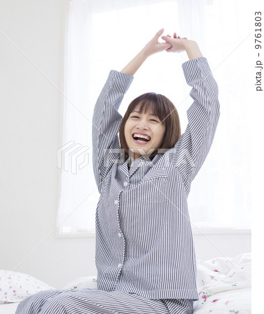 伸びをする笑顔の女性 9761803