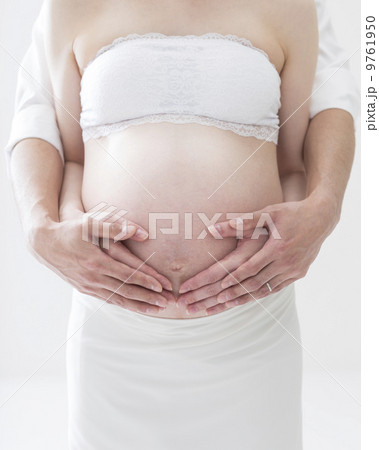 お腹に手をあてる妊婦と夫 9761950