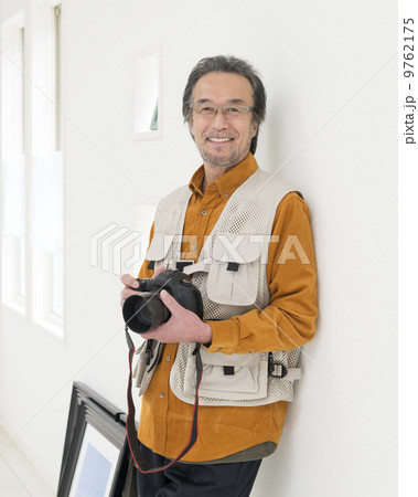 カメラを持って立つ中高年男性 9762175