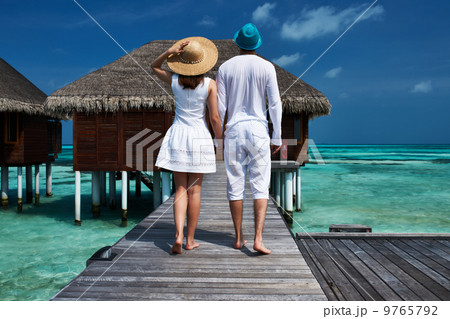 Couple on a beach jetty at Maldives 9765792