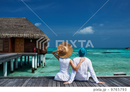 Couple on a beach jetty at Maldives 9765793