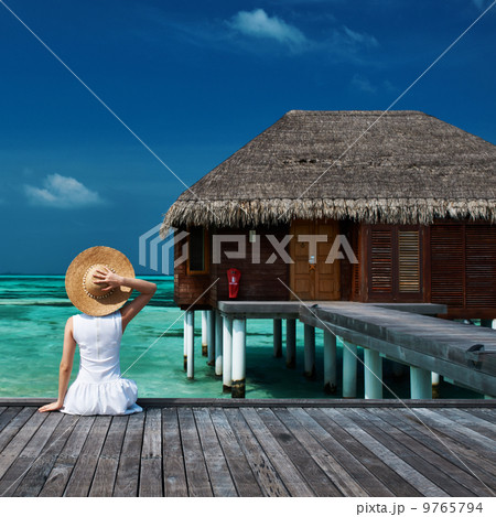 Woman on a beach jetty at Maldives 9765794