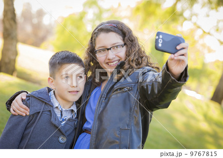 Brother and Sister Taking Cell Phone Picture of Themselves 9767815