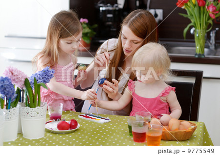 Mother and her daughters painting Easter eggs Mother and her daughters painting Easter eggs 9775549