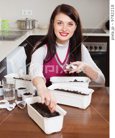 Brunette woman sowing seedlings Brunette woman sowing seedlings 9782218