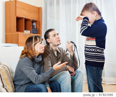 Mother and father with belt berating teenager Mother and father with belt berating teenager 9782490