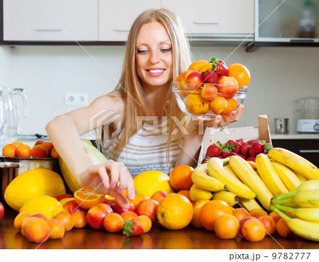 woman choosing fruits in home kitchen woman choosing fruits in home kitchen 9782777