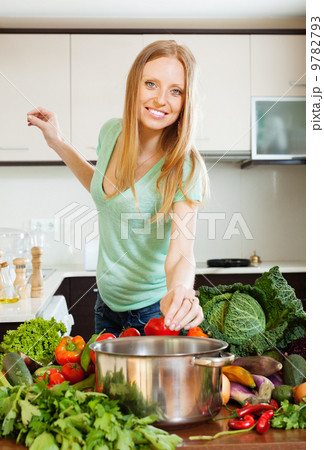 woman cooking from raw vegetables in home woman cooking from raw vegetables in home 9782793