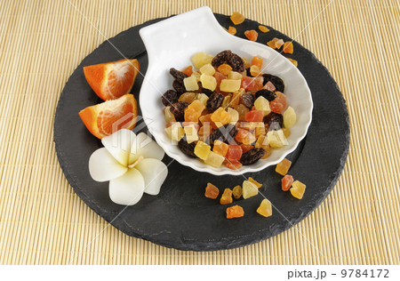 Dried fruits on stone plate with flower 9784172