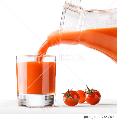 Tomato juice pouring from jug into a glass Tomato juice pouring from jug into a glass 9785767