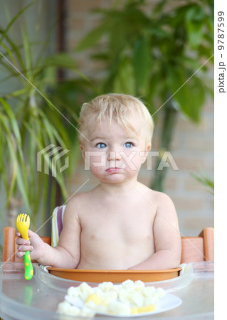 Adorable toddler girl eating healthy food, steamed vegetables 9787599