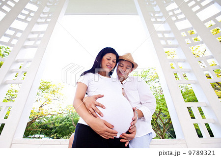 Beautiful happily married couple sharing a tender moment in a gazebo. 9789321