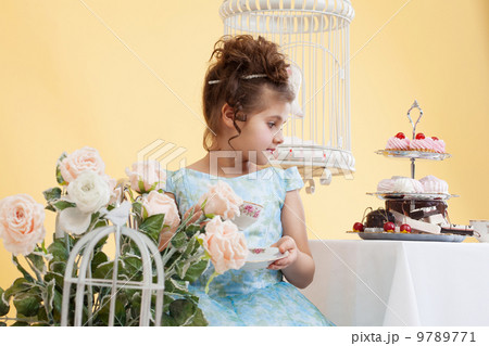 Shot of cute little lady drinking tea in studio 9789771
