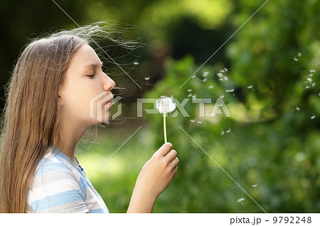 teenage girl blowing a dandelion teenage girl blowing a dandelion 9792248