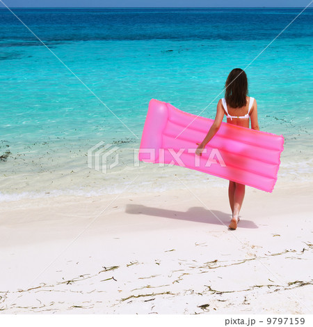 Woman with pink inflatable raft at the beach Woman with pink inflatable raft at the beach 9797159