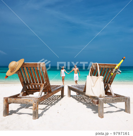 Couple in white running on a beach at Maldives 9797161