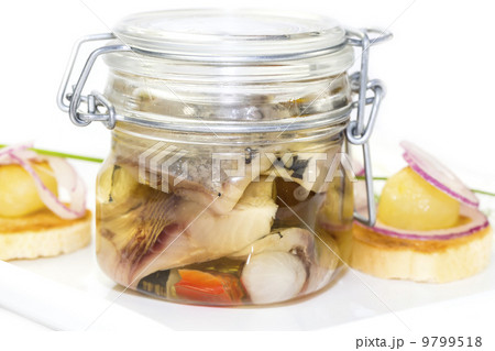 pickled herring in a glass jar with potato canapes 9799518