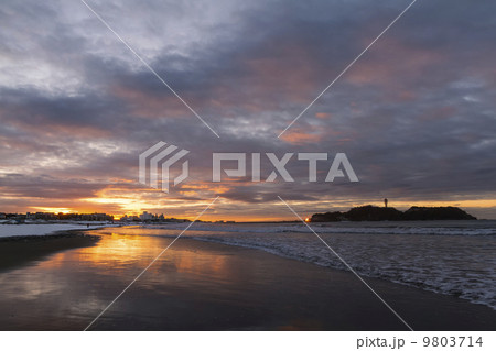 大雪の翌日の朝焼けの中の江の島と海岸 9803714