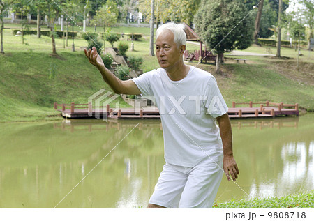 asian senior performing taichi 9808718