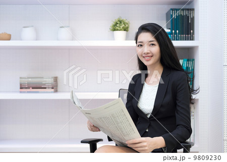 Young business woman in office reading newspaper  9809230