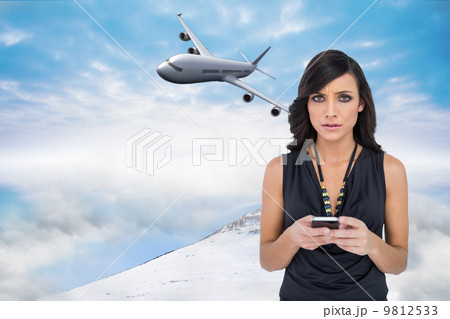 Composite image of serious elegant brown haired model texting Composite image of serious elegant brown haired model texting 9812533
