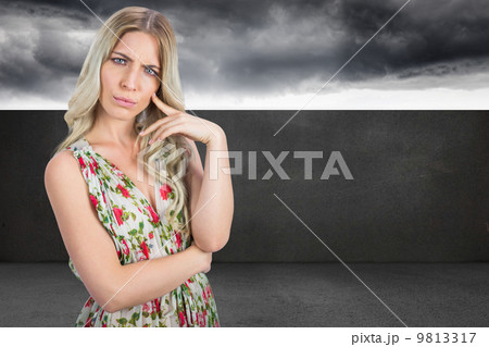 Composite image of frowning pretty blonde wearing flowered dress 9813317