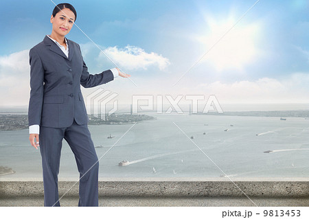 Composite image of standing businesswoman presenting 9813453