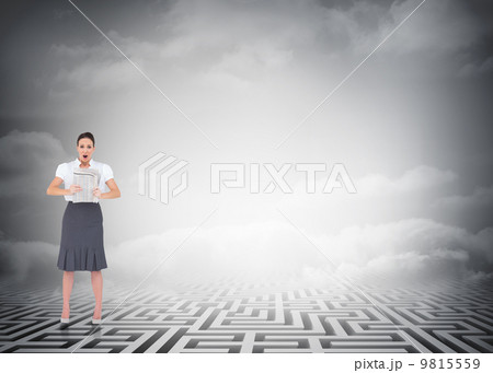 Composite image of shocked stylish businesswoman holding newspap Composite image of shocked stylish businesswoman holding newspap 9815559