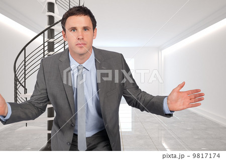 Composite image of businessman posing with hands out 9817174