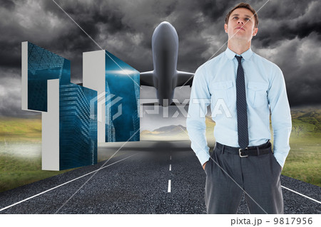 Composite image of serious businessman standing with hands in po 9817956