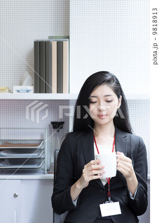 Young business woman having coffee taking a break from work 9818913