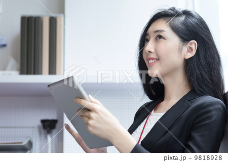 Young business woman in office cubicle using ipad portable digital tablet Young business woman in office cubicle using ipad portable digital tablet 9818928