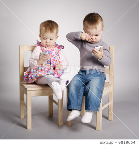 boy and girl playing with mobile phones boy and girl playing with mobile phones 9819654