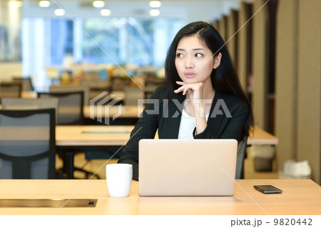 Young business woman indoor office working in front of computer 9820442