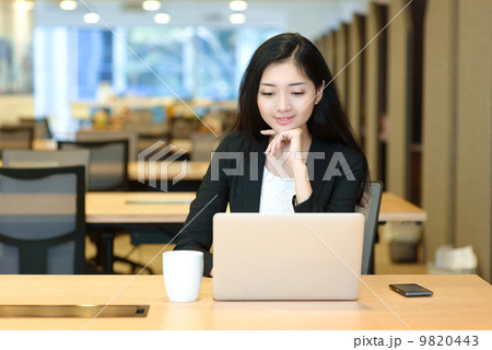 Young business woman indoor office working in front of computer Young business woman indoor office working in front of computer 9820443