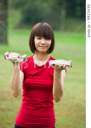 asian girl dumbbell workout outdoor 9823436