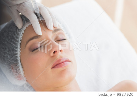 Woman recieving botox injection in forehead 9827920