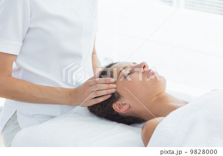 Woman receiving head massage from therapist Woman receiving head massage from therapist 9828000