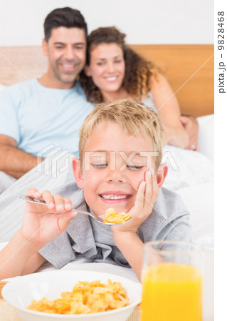 Cute young family having breakfast in bed 9828468